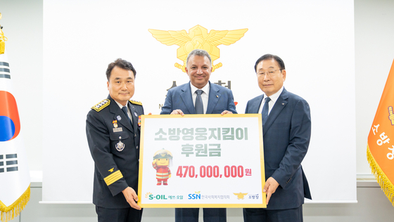 S-Oil CEO Anwar A. Al-Hejazi, center, poses for a photo with National Fire Agency chief Nam Hwa-yeong, left, and Korea National Council on Social Welfare chief Kim Sung-yi, right, during a donation ceremony held at the National Fire Agency headquarters in Sejong, Monday. [S-OIL]