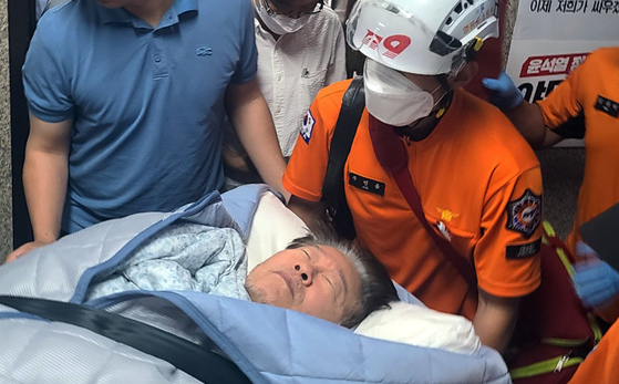 Emergency respondents take Democratic Party leader Lee Jae-myung, who has been on a hunger strike for 19 days, to a nearby hospital from his office in Yeouido, Seoul, on Monday. [YONHAP] 