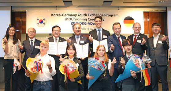 Student and teacher representatives of high schools in Seoul pose with German Ambassador-designate to Korea Georg Schmidt, third from right in second row; and Kim Hyo-joon, chairman of the Alumninetzwerk Deutschland-Korea (Adeko), fifth from right in second row, after a youth exchange agreement was signed between German and Korean associations and Adeko in Seoul on Monday. [PARK SANG-MOON]