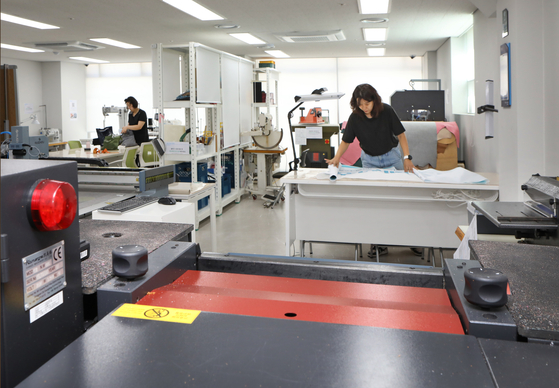 People make leather goods in the Seoul Leather Manufacturing Support Center's workroom in Gangdong District, eastern Seoul, on Thursday. Individuals are required to book a session to use the facility and complete a safety lesson. [PARK SANG-MOON]