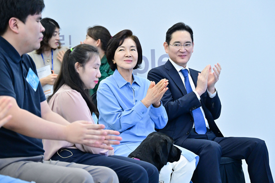 Samsung Electronics Chairman Lee Jae-yong, far right, and Lee Kun-hee's wife Hong Ra-hee applaud as trained guide dogs meet their new companions. [SAMSUNG]