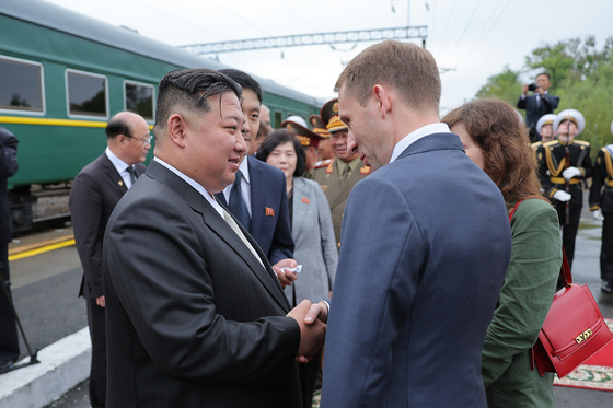 In this photo released by the Rodong Sinmun, the newspaper published by the North's ruling Workers' Party, regime leader Kim Jong-un is sent off by Russian Minister of Natural Resources and Ecology Alexander Kozlov at a station in Artyom, near Vladivostok, Russia, on Sunday. [NEWS1]