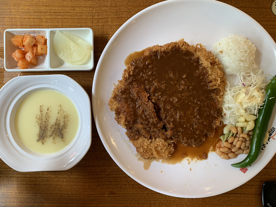Namsan tonkatsu consists of a large pork cutlet, smothered in a sweet and sour demi-glace sauce. It is often served with shredded cabbage, macaroni salad, baked beans, rice, green chili pepper, corn soup, kimchi and kkakdugi (spicy fermented radish). [LEE JIAN]