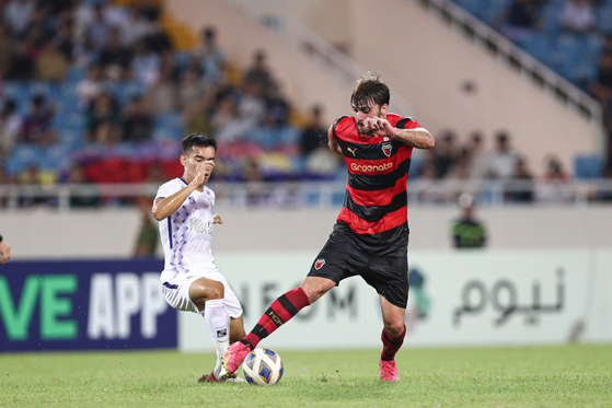 The Pohang Steelers' Zeca, right, in action during an AFC Champions League Group J match against Hanoi FC at My Dinh National Stadium in Hanoi, Vietnam on Wednesday. [AFC]
