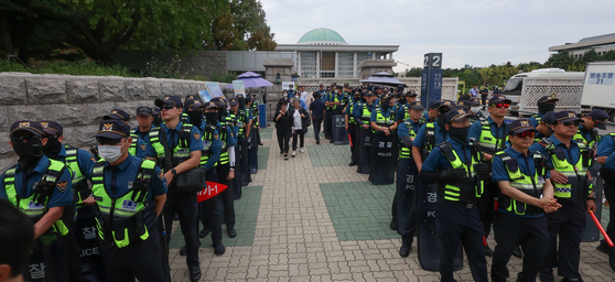 Police officers guard the main entrance of the National Assembly in Yeouido on Thursday. Supporters of the Democratic Party leader Lee Jae-myung tried to enter the Assembly ground to protest the National Assembly's vote on Thursday on whether to let the court decide on an arrest warrant for Lee. [YONHAP] 