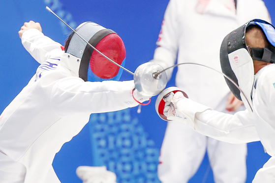 Korea's Lee Ji-hoon, left, competes in a fencing ranking match as part of the modern pentathlon competition at the Hangzhou Asian Games in Hangzhou, China on Wednesday.  [NEWS1]