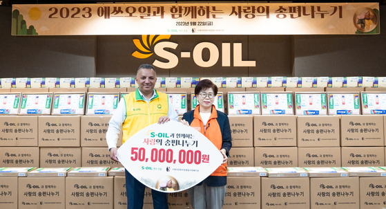 S-Oil CEO Anwar A. Al-Hejazi, left, delivers 500 Chuseok gift packages to a local community center with the Mapo Community Welfare Center of Loveaid Foundation on Friday. [S-OIL]