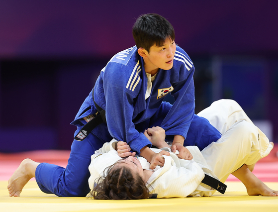 Jung Ye-rin, wearing blue, defeats Kazakhstan's Galiya Tynbayeva to secure Korea a bronze medal in the women's judo -52 kilograms division in Hangzhou, China on Sunday. [YONHAP]