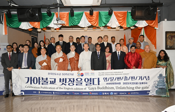 Monk Domyeong, seventh from front right, Indian Ambassador to Korea Amit Kumar, sixth from front right, and historians of both India and Korea celebrate the publication of Monk Domyeong's book, “Gaya Buddhism, Unlatching the Gate,” into English at the Indian Embassy in Seoul on Friday. [EMBASSY OF INDIA IN KOREA]