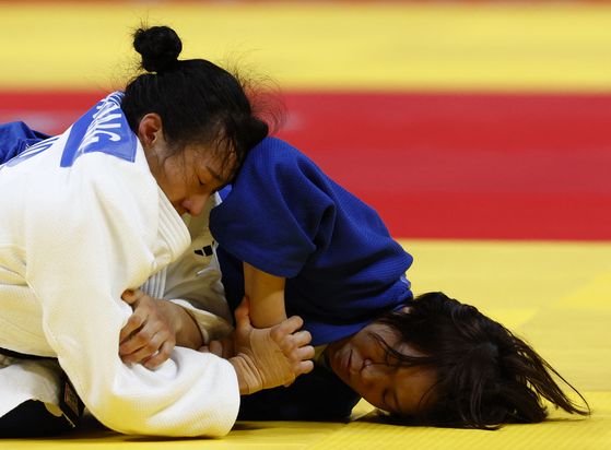 Park Eun-song, wearing blue, loses to Japan's Momo Tamaoki in the semifinal match of the women's -57 kilograms division but then finishes with a bronze medal win on Monday. [REUTEURS/YONHAP]
