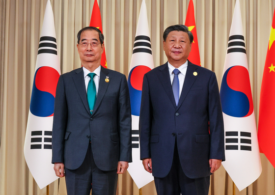 South Korean Prime Minister Han Duck-soo, left, stands alongside Chinese President Xi Jinping at their meeting on the sidelines of the opening of the 19th Asian Games in Hangzhou on Saturday afternoon. [OFFICE OF THE PRIME MINISTER]