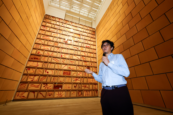 Artist Jung Yeon-doo stands in front of his 14-meter (46-foot)-tall installation piece “Wall of Blades” (2023) on display at the Museum of Modern and Contemporary Art (MMCA) Seoul for the "MMCA Hyundai Motor Series 2023" titled “One Hundred Years of Travels,″ during a press tour on Sept. 5. [MMCA]