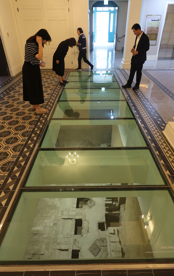 Visitors during the pre-opening on Monday look down the basement cellar through a see-through glass. [YONHAP] 