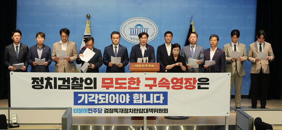 Members of the liberal Democratic Party read statements against what they characterize as "prosecutiorial dictatorship" at the National Assembly in Seoul on Monday. [YONHAP]
