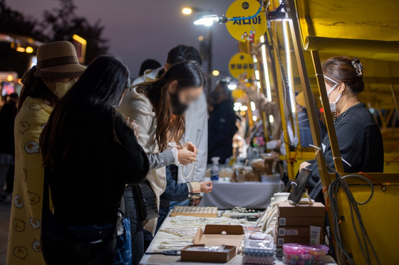 Visitors check the handicraft booths at Hangang Moonlight Market at Yeouido Hangang Park, Yeongdeungpo District, western Seoul. [SEOUL METROPOLITAN GOVERNMENT]