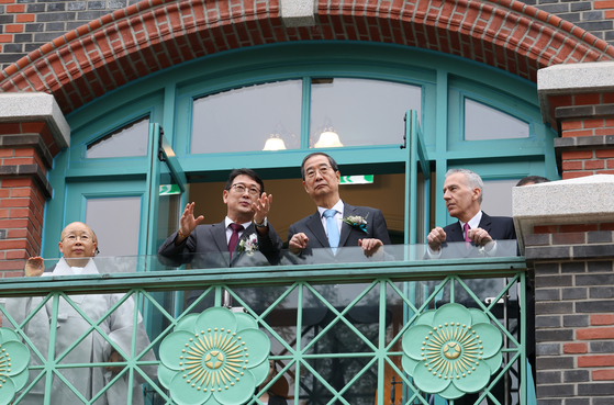 Prime Minister Han Duck-soo, second from right, and Choi Eung-chon, head of the Cultural Heritage Administration, third from right, look out from the new Dondeokjeon building on Monday during the opening ceremony of the new building. [NEWS1] 