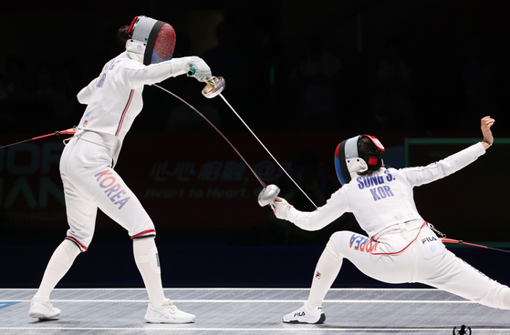 Choi In-jeong, left, and Song Se-ra compete in the women's epee final at the Hangzhou Asian games at Hangzhou Dianzi University Gymnasium in Hangzhou, China on Sunday.  [YONHAP] 