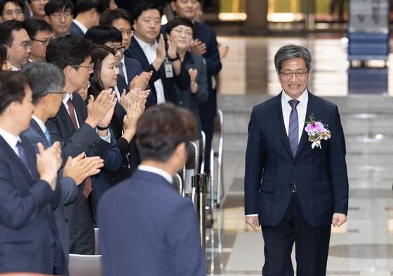 Kim Myeong-su, the outgoing Supreme Court chief justice, right, receives applause at his retirement ceremony at the top court’s headquarters in Seocho District, southern Seoul, Friday. His six-year term as Supreme Court chief justice ended Sunday. [NEWS1]