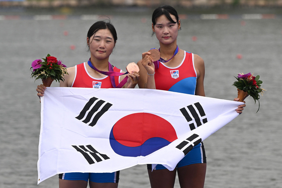Bronze medalist Kim Ha-yeong and Lee Soo-bin of Korea pose during the medal ceremony for the women's pair rowing event during the Asian Games in Hangzhou, China on Monday.  [AFP/YONHAP]