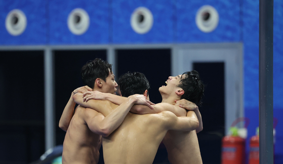 The Korean men's 4x200 meter freestyle relay team of Yang Jae-hoon, Lee Ho-joon, Kim Woo-min and Hwang Sun-woo celebrate after winning the nation's first-ever gold and breaking the Asian record in the discipline on Monday. [YONHAP]