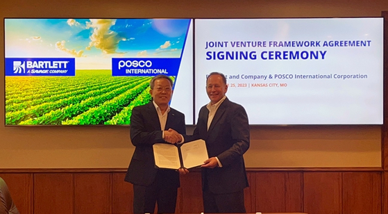 Posco International CEO Jeong Tak, left, and Kirk W. Aubry, president and CEO of Savage, the parent of Bartlett and Company, pose for a photo during a joint venture framework agreement signing ceremony held in Kansas City on Monday. [POSCO INTERNATIONAL]  