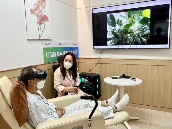 A patient hospitalized at the Seoul Rehabilitation Hospital experiencing VR contents of the Sejong National Arboretum with the Digital Healing Garden. [DUNAMU]
