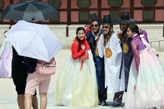Tourists in hanbok, or traditional Korean dress, post for a photo at Gyeongbok Palace in central Seoul on Sept. 6. [NEWS 1] 