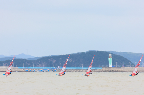 William McMillan of Thailand, Ikeda Kensei of Japan, Lee Tae-hoon of South Korea and Oh Elkan Reshawn of Singapore compete during the men's windsurfing iQFoil race at the 19th Asian Games in Ningbo, China on Saturday. [XINHUA]