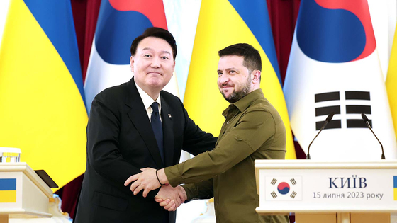Korean President Yoon Suk Yeol, left, shakes hands with Ukrainian President Volodymyr Zelensky during their summit in Kyiv, Ukraine, in July. During the summit, Yoon promised to offer humanitarian aid to Ukrainian students studying in Korea. [PRESIDENTIAL OFFICE]