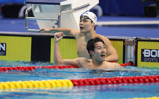 Hwang Sun-woo, front, celebrates with Lee Ho-joon after finishing the men’s 200-meter freestyle final at the Hangzhou Asian Games held at Hangzhou Olympic Sports Centre Aquatic Sports Arena in Hangzhou, China on Wednesday. [YONHAP] 