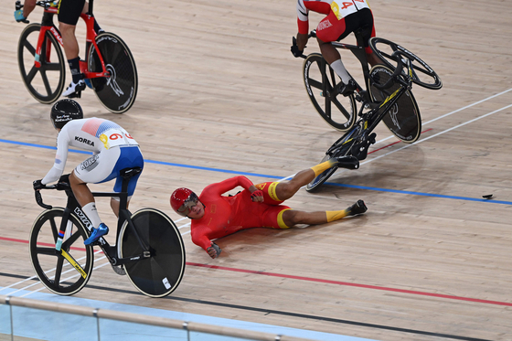 A Korean cyclist passes on the inside as China's Wu Junjie falls in the men's madison final at the Asian Games in Hangzhou, China on Friday.  [AFP/YONHAP]