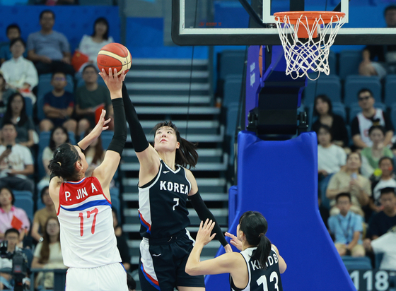 South Korea's Park Ji-su, center, defends against North Korea's Pak Jin-a, left, in the second women's basketball Group C game at the 19th Asian Games in Hangzhou, China on Friday. [YONHAP]