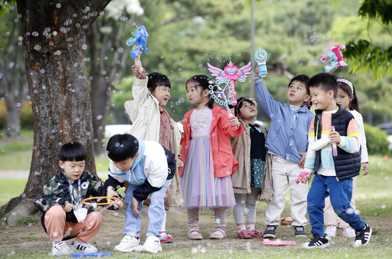 Children supervised by the workplace childcare center at Buk District of Gwangju play with bubbles at Chonnam National University. [BUK DISTRICT OFFICE]
