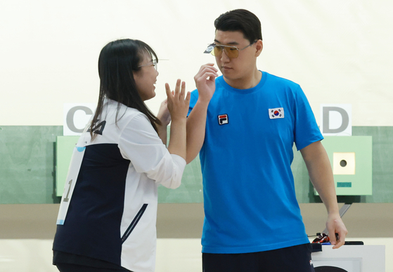 Kim Bo-mi, left, celebrates with Lee Won-ho after winning a bronze medal in the 10-meter air pistol mixed team bronze medal match at the Hangzhou Asian Games held at Fuyang Yinhu Sports Center in Hangzhou, China on Saturday. [YONHAP]