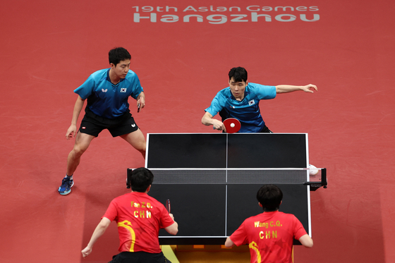 Korean table tennis players Jang Woo-jin and Lim Jong-hoon compete in the men's doubles final at the Hangzhou Asian Games against China's Fan Zhendong and Wang Chuqin at Gongshu Canal Sports Park Gymnasium in Hangzhou, China on Sunday. [REUTERS/YONHAP]