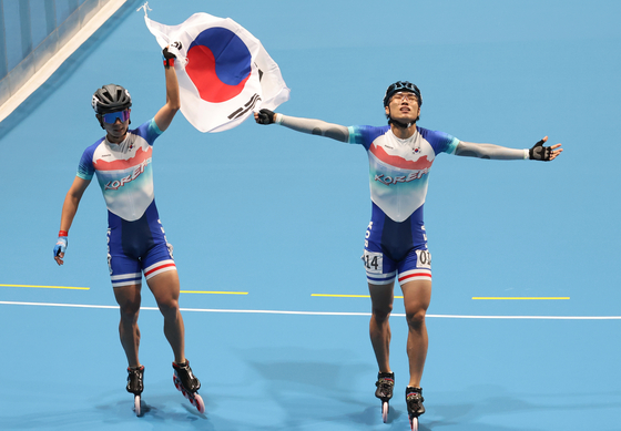 Choi Gwang-ho and Jung Cheol-Won celebrate after taking gold and silver in the men's speed skating 1,000-meter sprint at the QT Roller Sports Centre in Hangzhou, China on Sunday.  [YONHAP]