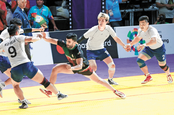 Korea, in white, competes against Iran in the men’s kabaddi final at the 2018 Asian Games. [YONHAP]