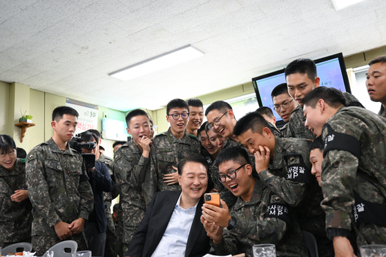 President Yoon Suk Yeol, center, makes a video call with families of soldiers during a visit to the Army’s 25th Infantry Division in Yeoncheon County, Gyeonggi, on Sunday to mark the 75th Armed Forces Day during the Chuseok holiday. [PRESIDENTIAL OFFICE]