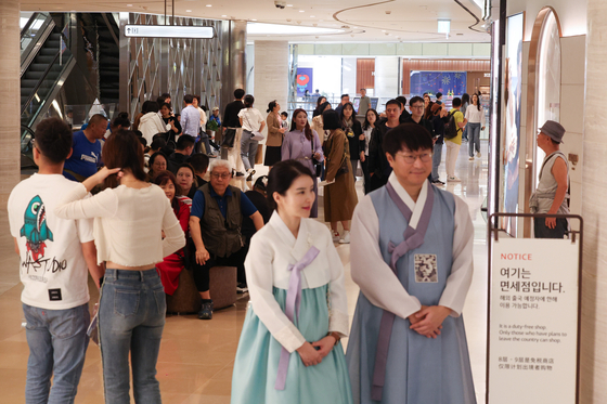 Chinese group tourists shop at a duty-free shop at Lotte World Tower in Jamsil, southern Seoul, Monday. [YONHAP] 
