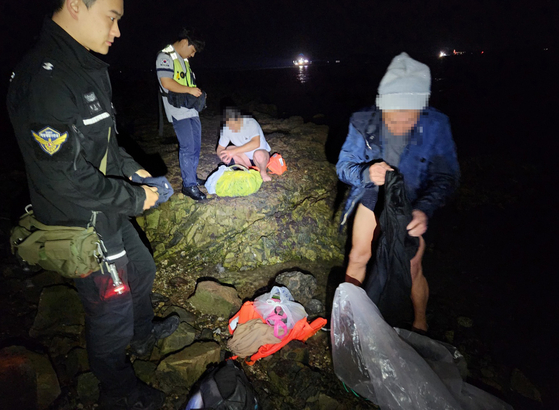 The Boryeong coast guard apprehends Chinese nationals that are accused of trying to illegally attempting to enter the country in Boryeong, South Chungcheong, on Tuesday. The Chinese nationals tried to swim to shore on a life jacket. [KOREA COAST GUARD]