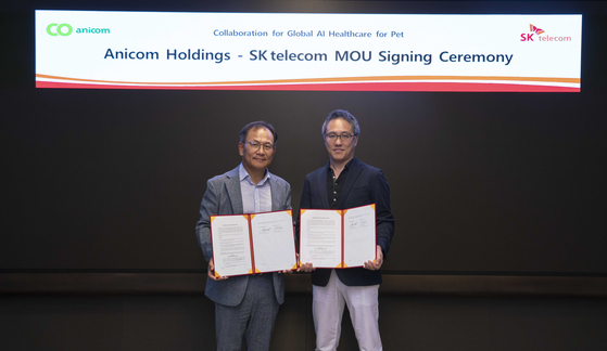 SK Telecom's chief development officer Ha Min-yong, left, and Anicom Holdings' founder and CEO Nobuaki Komori, pose for the photo after signing a partnership at SK Telecom's headquarters in Jung District, central Seoul, on Sept. 20. [SK TELECOM]