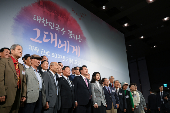 President Yoon Suk Yeol and first lady Kim Keon Hee, front row center, pose for a commemorative photo during a luncheon marking the 60th anniversary since the first Korean nurses and miners were dispatched to Germany, aiding South Korea's economic development, at Grand Walkerhill Hotel in eastern Seoul Wednesday. [PRESIDENTIAL OFFICE]