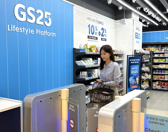 GS25 opened its DX LAB Gasan Smart branch in southern Seoul on Thursday. The store relies entirely on AI technology, including entry access, customer service, product purchases, and payment processing, with no human intervention. Payments are automatically processed as customers exit with their chosen items, and overlooked promotional items are stored on the GS25 mobile app. Convenience store rivals such as CU, Emart24 and 7-Eleven are also operating AI-based, fully unmanned stores, while many of them are located in more enclosed or limited settings, often within their corporate headquarters. [GS RETAIL]