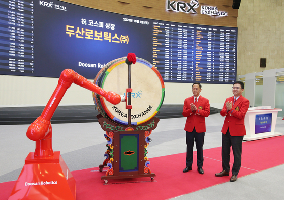 A robot bangs on a drum celebrating the listing of Doosan Robotics, a collaborative robot supplier, at the Korea Exchange in Yeouido, western Seoul, on Thursday. [DOOSAN ROBOTICS]