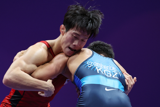 Korean wrestler Chung Han-jae, right, competes in a men's Greco-Roman 60-kilogram division bout against Sharshenbekov Zholaman of Kyrgyzstan at Lin’an Sports Culture & Exhibition Centre in Hangzhou, China on Wednesday. [YONHAP] 