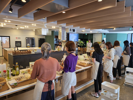 Attendees prepare food during a vegetarian cooking class held by Sempio Foods Company at the company's headquarters in Jung District, central Seoul, on Thursday. [SEMPIO FOODS COMPANY]