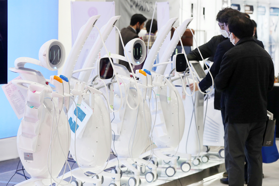Visitors examine medical equipment used in plastic surgeries at a technology fair hosted by the Korean Aesthetic Surgery & Laser Society at the aT Center in Seocho District, southern Seoul, on Feb. 26, 2023. [NEWS1]