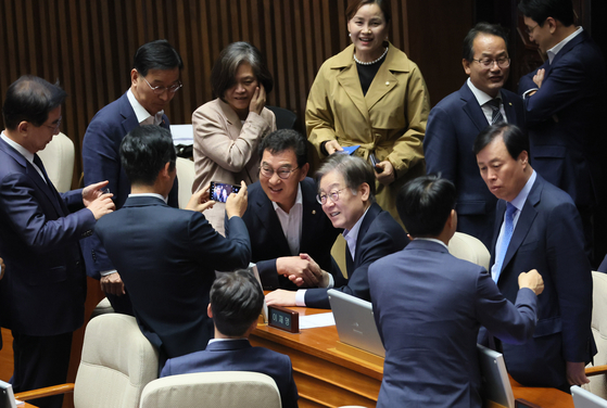 Democratic Party leader Lee Jae-myung take pictures with DP legislators at the National Assembly on Friday. It was his first visit since he was taken to the hospital on Sept. 18, the same day that the prosecutors' office filed an arrest warrant against the leader of the biggest political party. [YONHAP]
