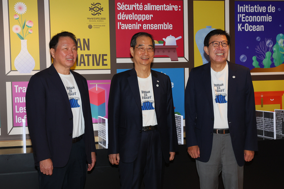From left, Korea Chamber of Commerce and Industry Chairman Chey Tae-won, Prime Minister Han Duck-soo and Busan Mayor Park Heong-joon attend a special correspondent dinner in Paris, France, on Sunday, sporting "Busan is ready" T-shirts to promote Busan's bid to host the World Expo 2030. [PRIME MINISTER'S SECRETARIAT]
