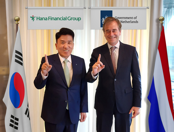 Hana Financial Group Chairman Ham Young-joo, left, and Rene van Hell, Netherlands’ Ambassador for Sustainable Development, pose for a photo during a meeting held in Hague on Friday. [HANA FINANCIAL GROUP]